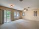 Inviting living room features a ceiling fan and sliding glass doors leading to the outdoors at 564 Mount Olympus Blvd, New Smyrna Beach, FL 32168