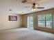 Bright living room with sliding glass doors and a large window overlooking the serene backyard and water at 564 Mount Olympus Blvd, New Smyrna Beach, FL 32168