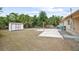 Home's fenced backyard featuring a storage shed, patio and sparse landscaping at 566 S Floyd Cir, Deltona, FL 32725
