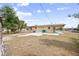 Home's fenced backyard features a small patio, green trash bins and sparse landscaping at 566 S Floyd Cir, Deltona, FL 32725