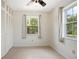 This cozy bedroom offers tile flooring, neutral walls, a ceiling fan, and two windows for natural light at 566 S Floyd Cir, Deltona, FL 32725