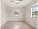 This simple bedroom features tile floors, neutral walls, natural light, and a ceiling fan at 566 S Floyd Cir, Deltona, FL 32725