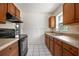 Functional kitchen with black appliances and wooden cabinets at 566 S Floyd Cir, Deltona, FL 32725