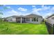 Spacious backyard featuring lush green grass and a screened-in lanai for outdoor enjoyment at 6212 W Fallsgrove Ln, Port Orange, FL 32128