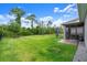 Large fenced backyard features lush greenery, mature trees and access to a screened in lanai at 6212 W Fallsgrove Ln, Port Orange, FL 32128