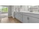 Modern bathroom with dual vanity, gray cabinets, quartz countertops and hardwood floors at 6212 W Fallsgrove Ln, Port Orange, FL 32128