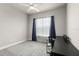 Neutral bedroom featuring a ceiling fan, grey carpet, a large window, and an office desk at 6212 W Fallsgrove Ln, Port Orange, FL 32128