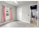 This bedroom offers carpet, a ceiling fan, a window with pink curtains, and a closet at 6212 W Fallsgrove Ln, Port Orange, FL 32128
