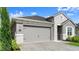 Two-car garage with stone veneer accents and a paved driveway with meticulous landscaping at 6212 W Fallsgrove Ln, Port Orange, FL 32128