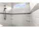 Modern shower with white subway tile, glass shelves, and a handheld shower head at 6212 W Fallsgrove Ln, Port Orange, FL 32128