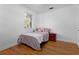 Bedroom with hardwood floors, a comfortable bed, and a side table for a cozy atmosphere at 632 Tarragona Way, Daytona Beach, FL 32114