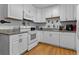 All-white kitchen featuring sleek cabinets, granite counters, and modern appliances at 632 Tarragona Way, Daytona Beach, FL 32114