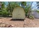 Backyard shed with double doors and traditional design, surrounded by mature trees at 632 Tarragona Way, Daytona Beach, FL 32114