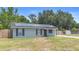 Front exterior of the home with solar panels on the roof, grassy lawn, and a wood fence on a sunny day at 6509 Lake Lerla Dr, Apopka, FL 32712
