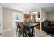 View of the open kitchen featuring wooden cabinets and modern lighting adjoining a dining area with a large table at 6509 Lake Lerla Dr, Apopka, FL 32712