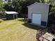 Overhead shot of both the metal and wood sheds in the backyard with grass and surrounding trees at 6509 Lake Lerla Dr, Apopka, FL 32712