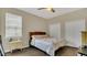 Well-lit bedroom features a window, ceiling fan, and double door closet at 680 Preakness Cir, Deland, FL 32724