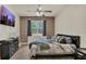 Cozy bedroom features ceiling fan, patterned accent wall, and hardwood floors at 680 Preakness Cir, Deland, FL 32724