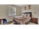 Bright bedroom featuring a window with light-filtering blinds and modern style furnishings at 680 Preakness Cir, Deland, FL 32724
