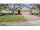 Charming single Gathering house featuring tan siding, arched doorway, and manicured lawn at 680 Preakness Cir, Deland, FL 32724
