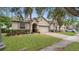 Charming single Gathering house featuring tan siding, arched doorway, and manicured lawn at 680 Preakness Cir, Deland, FL 32724