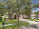 Traditional home featuring a well-manicured front yard, arched entryway, and brick-paved driveway at 680 Preakness Cir, Deland, FL 32724