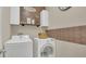 Bright laundry room with front loading washer and dryer, cabinets, and built in shelving at 680 Preakness Cir, Deland, FL 32724