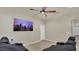 Comfortable living room featuring large screen, ceiling fan, and neutral color palette at 680 Preakness Cir, Deland, FL 32724