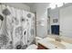 Bathroom with decorative shower curtain, white shelves, and neutral-colored vanity at 6820 Vintage Ln, Port Orange, FL 32128