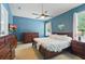 Cozy primary bedroom boasts a ceiling fan, natural light, and classic wood furniture at 6820 Vintage Ln, Port Orange, FL 32128
