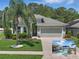 Landscaped home featuring a well-manicured lawn, palm tree, and gray two-car garage at 6820 Vintage Ln, Port Orange, FL 32128