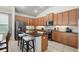 Modern kitchen with dark countertops, wood cabinetry, and stainless steel appliances, as well as an island with barstool seating at 6820 Vintage Ln, Port Orange, FL 32128