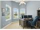 Bright home office featuring a ceiling fan, light blue walls and an expansive work desk with monitor displays, providing ample space at 6820 Vintage Ln, Port Orange, FL 32128