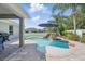 Backyard pool featuring a rock waterfall, umbrella, and brick paver patio creating an inviting outdoor living space at 6820 Vintage Ln, Port Orange, FL 32128