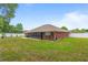 A fenced backyard features a screened patio and ample green space at 703 Elkhorn Fern Ln, Deland, FL 32720