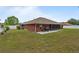 Large backyard with a well-manicured lawn, white fencing for privacy, and a brick home adding to its charm at 703 Elkhorn Fern Ln, Deland, FL 32720
