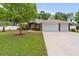 Well-maintained front yard and landscaped property with a brick home featuring an attached two-car garage at 703 Elkhorn Fern Ln, Deland, FL 32720