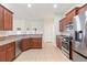 This kitchen offers stainless steel appliances, tile floors, and wood cabinets at 703 Elkhorn Fern Ln, Deland, FL 32720