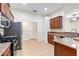 This kitchen features tile floors, stainless steel appliances, and dark wood cabinets at 703 Elkhorn Fern Ln, Deland, FL 32720