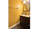Bathroom view with wood cabinet and sink, mirror, and yellow walls plus minimal decor giving it a simple and clean aesthetic at 783 Shropshire Loop, Sanford, FL 32771