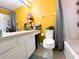 Bright bathroom with a combination shower and tub and a white vanity and white toilet, and some wall storage at 783 Shropshire Loop, Sanford, FL 32771