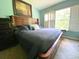 Cozy bedroom featuring a king-sized bed, blue walls, and large window with plantation shutters at 783 Shropshire Loop, Sanford, FL 32771
