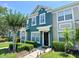 Charming blue townhome with well-manicured landscaping, walkway, and dark front door, with a tree on the left at 783 Shropshire Loop, Sanford, FL 32771
