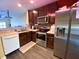 Kitchen with stainless steel appliances, dark cabinets, and light countertops featuring a double sink and white dishwasher at 783 Shropshire Loop, Sanford, FL 32771