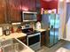 Kitchen showcases stainless steel appliances, dark wood cabinets, and light countertops, well lit and roomy at 783 Shropshire Loop, Sanford, FL 32771