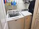 Efficient laundry room with white washer and dryer, storage shelf, and hanging rack for convenience at 783 Shropshire Loop, Sanford, FL 32771