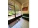 Enclosed patio with tiled floor, screen windows showcasing a view of the landscape, and bench at 783 Shropshire Loop, Sanford, FL 32771