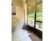 Enclosed patio area with tile flooring, screen windows, and view of the outdoor landscaping at 783 Shropshire Loop, Sanford, FL 32771
