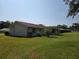 Expansive backyard showcasing the home's rear exterior with a neutral siding and well-maintained lawn under a blue sky at 808 Scrub Oak St, South Daytona, FL 32119