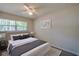 Bright bedroom with a large window, ceiling fan, stylish rug, and neutral decor for a relaxing atmosphere at 818 Sugar House Blvd, Port Orange, FL 32129